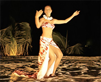 Nachts tanzt eine Frau mit knappen Oberteil und langem Rock