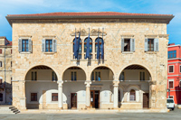 Ein Sandsteingenäude mit Tornbögen